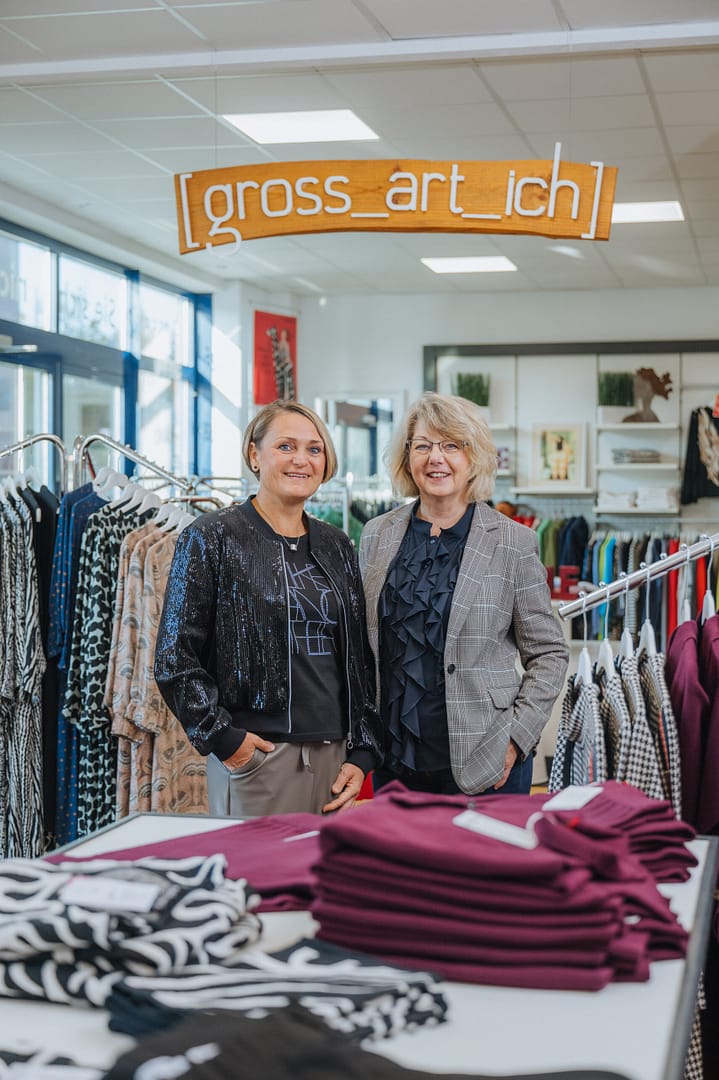 Anke Bahr und ihre Mitarbeiterin lächeln im Fachgeschäft für Große Größen im Modehaus "gross-art-ich" in die Kamera